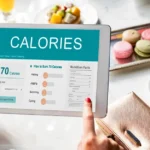 Persona usando calculadora para calcular su gasto calórico