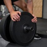 Ejercicios de fuerza para bajar peso: entrenamiento de hombre y mujer con pesas, fortaleciendo músculos y quemando grasa.