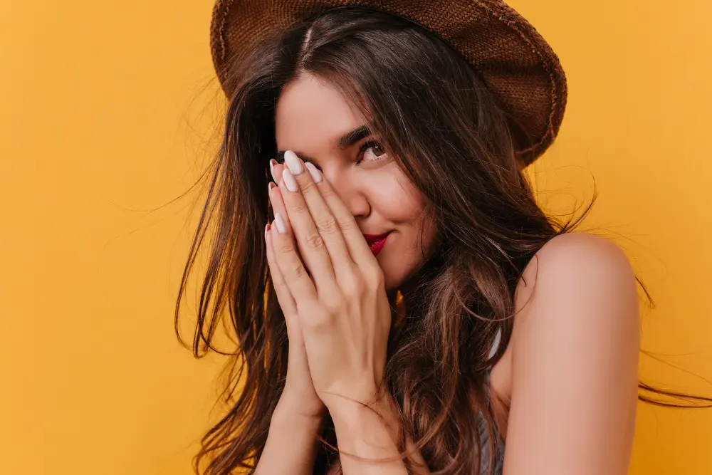 Mujer con cabello brillante y uñas fuertes, mostrando resultados de fortalecer el cabello y las uñas con suplementos