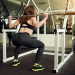 Mujer realizando rutina de glúteos y piernas en el gimnasio, fortaleciendo glúteos y piernas